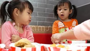 亚洲同胞小女孩喜欢吃<strong>炸</strong>鸡，薯条和花蜜在服务商店与她的家人。 <strong>肯德基</strong>是一家